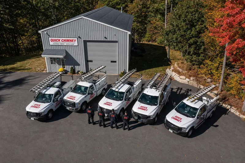 Quick Chimney trucks with ladder racks lined up outside the shop, viewed from above